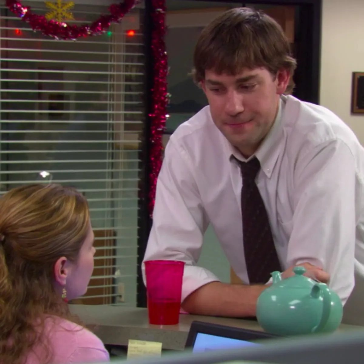Jim talking to Pam at her desk